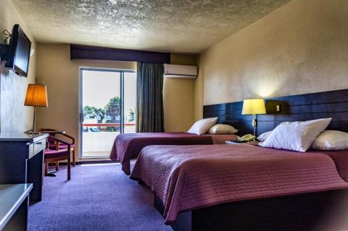 恩塞纳达港波萨达唐费尔南多酒店的酒店客房设有两张床和窗户。
