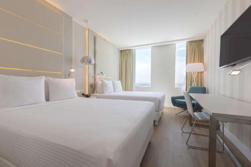 蒙特雷NH蒙特雷拉菲酒店的酒店客房配有两张床和一张书桌