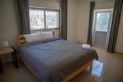 安曼Dali House的卧室内的一张床位,设有两个窗户