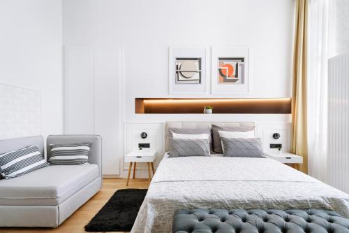 萨格勒布THE City Lodge - Boutique Apartments的一间卧室配有一张床和一张沙发