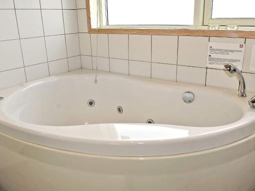 灵克宾6 person holiday home in Ringk bing的带浴缸的浴室和窗户