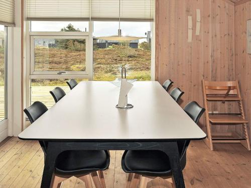 灵克宾6 person holiday home in Ringk bing的一间会议室,配有白色的桌子和椅子