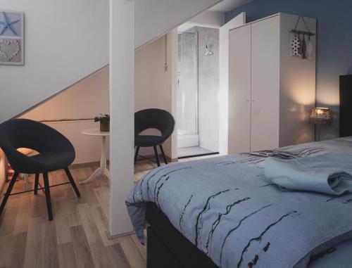 瓦瑟纳尔B&B Het Ruime Sop的一间卧室配有一张床、两把椅子和一张桌子