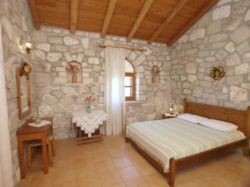 斯泰洛米诺斯Gerolakos Country Houses的一间卧室设有一张床和石墙