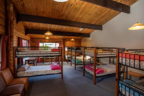 蒂阿瑙Te Anau Top 10 Holiday Park and Motels的小屋内带几张双层床的客房
