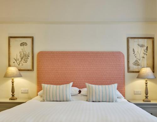 南莫尔顿The George的一间卧室配有一张带两盏灯的大型白色床。