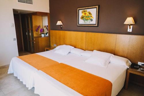 罗列特海岸阿尔巴塞勒克塔酒店的卧室配有一张白色大床和木制床头板