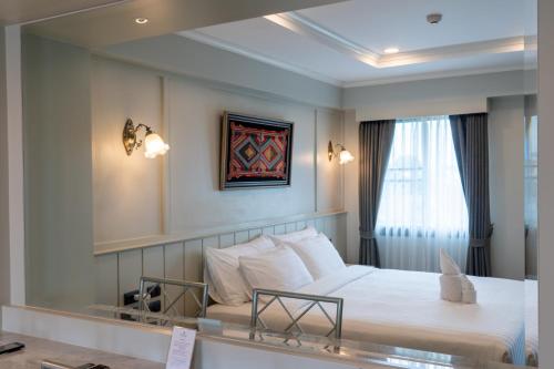 清迈Rimwiang的酒店客房,配有床和镜子