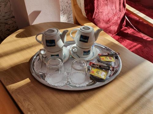 格武霍瓦济Hotel Sudety的盘子,桌子上放着两个茶壶和杯子