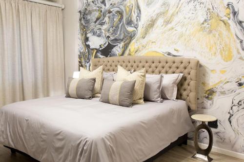 约翰内斯堡Melville Gap Guesthouse的卧室配有一张白色床,墙上挂有绘画作品