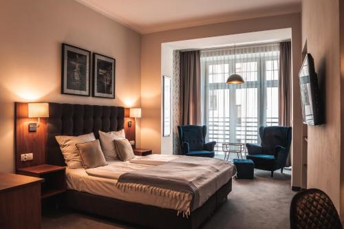 弗罗茨瓦夫Brassel Aparthotel的酒店客房,配有一张床和两把椅子