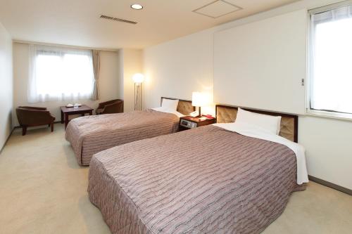 仙台绿色公园酒店 的酒店客房设有两张床和窗户。