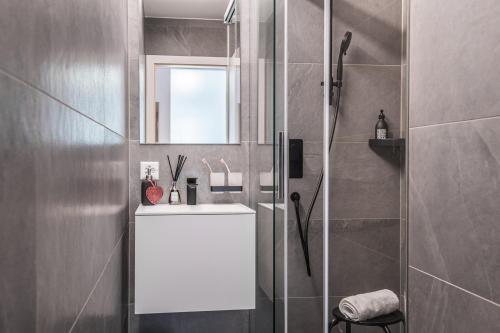 采尔马特Ascot-Zermatt的浴室配有白色水槽和淋浴。