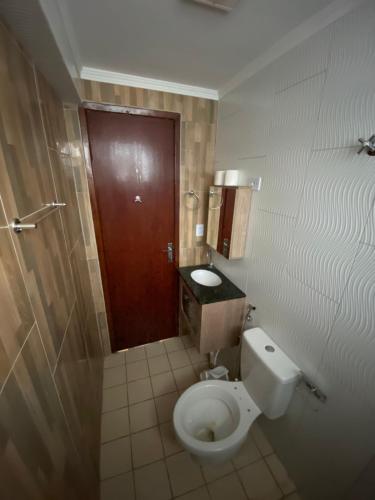ParanoáBoss Apartments的一间带卫生间和棕色门的浴室