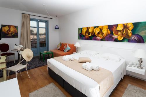 拉纳卡轻歌剧之家公寓的卧室配有白色的床和墙上的绘画作品