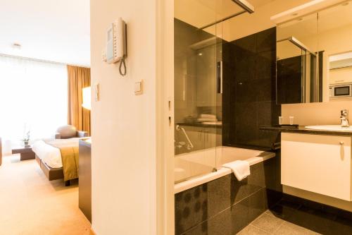 布鲁塞尔布鲁塞尔EU钻石套房公寓的带浴缸和盥洗盆的浴室