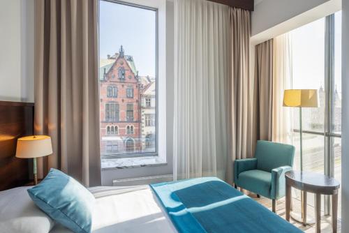 弗罗茨瓦夫欧罗帕姆酒店的酒店的客房 - 带一张床、椅子和窗户