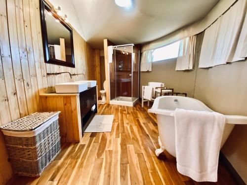 科尔切斯特ParkView Safari Lodge的带浴缸的浴室和木地板