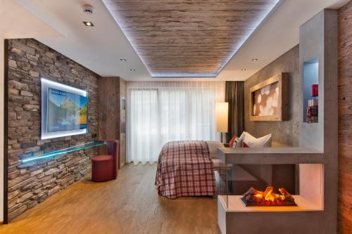 圣安东阿尔贝格PETE Alpine Boutique Hotel - klein und fein - Private SPA Suiten und Zimmer的酒店客房配有一张床和一个壁炉。