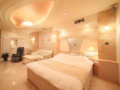 松山Hotel Fine Garden Matsuyama的酒店客房设有一张大床和一张沙发。