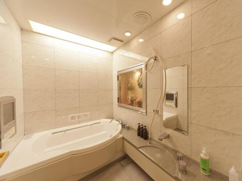 松山Hotel Fine Garden Matsuyama的白色的浴室设有浴缸和淋浴。