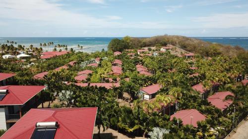 勒沃克兰乐村德拉蓬德度假村的享有粉红色屋顶和海洋的度假村空中景致