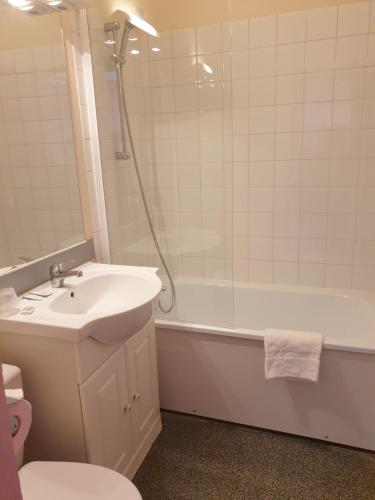 瓦尔瑟里恩河畔贝勒加尔德埃尔芒斯酒店的一间带水槽、浴缸和卫生间的浴室