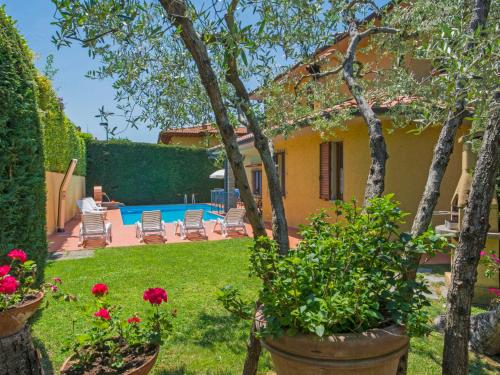 Villa BensiVilla Villa Giada by Interhome的一座带鲜花和游泳池的庭院