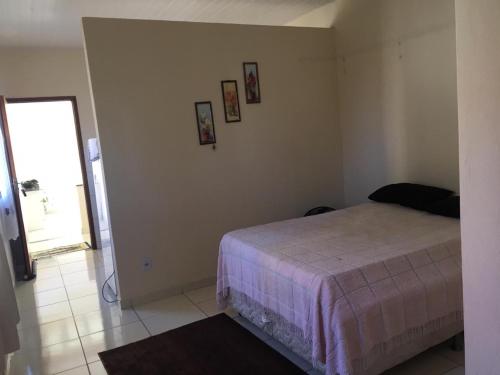 乌纳Apto Praia de Setiba的卧室配有一张床,墙上挂有图片