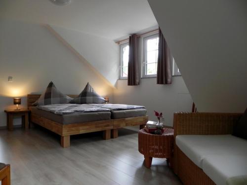 施托尔彭Ferienhaus Buschmuehle - Stolpen的一间卧室配有一张床、一张沙发和两个窗户。