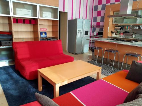 陶格夫匹尔斯Fuksija House的客厅配有红色的沙发和桌子