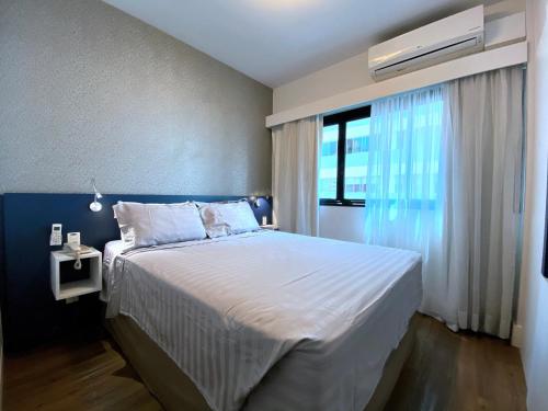 圣保罗Apartamento conforto - Itaim Bibi的一间卧室设有一张大床和一个窗户。
