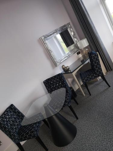 柯科迪迪恩公园酒店的用餐室配有椅子和带镜子的桌子