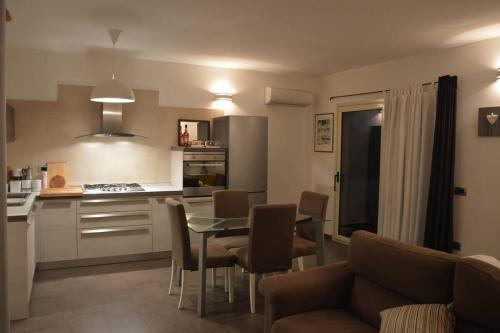 阿尔巴塔克斯Casa Vacanze Rocco的厨房以及带桌椅的起居室。