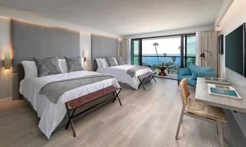 圣地亚哥拉霍亚湾套房酒店的美景酒店客房 - 带两张床和一张书桌