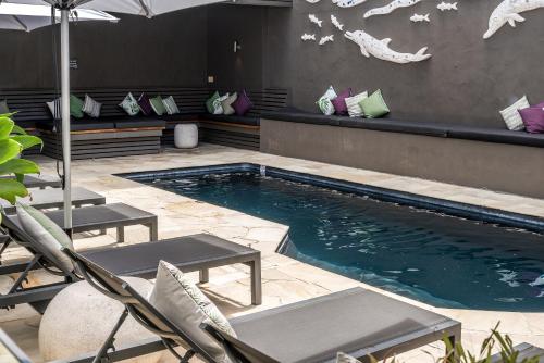 拜伦湾拜伦湾公寓式酒店的一个带两把椅子和遮阳伞的游泳池