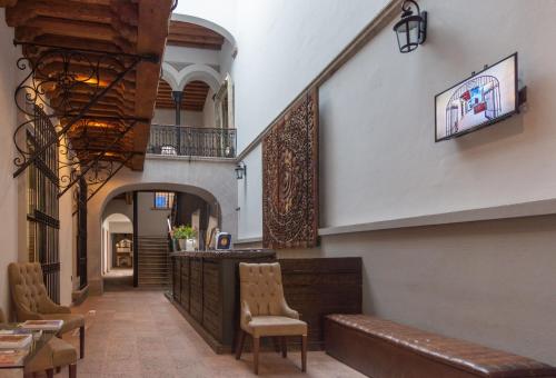 克雷塔罗马德罗酒店的大楼内带椅子和酒吧的走廊