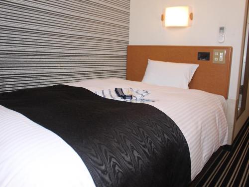 德岛APA德岛站前酒店的一间卧室配有一张带白色床单的大床