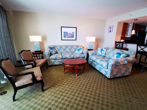 默特尔比奇Deluxe Ocean Front Two-Bedroom Condo in Sandy Beach Resort的客厅配有沙发和桌椅