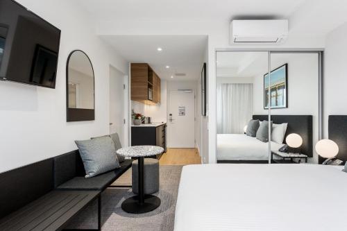 珀斯Quest Perth Ascot的一间卧室设有一张床和一间客厅。