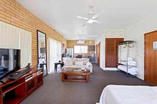 麦夸里港Fi's Beach House的客厅配有沙发和电视。