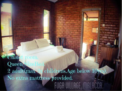 马六甲Fuga Village BeachGetaway的一间砖墙内白色床的卧室