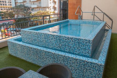 马尼拉The B Hotel Alabang的阳台的蓝色瓷砖游泳池