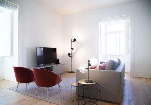 里斯本FLH Augusta's Arch Design Apartment的客厅配有白色沙发和红色椅子