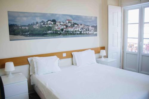 康斯坦西亚Casa João Chagas Guesthouse, Constância的卧室配有一张白色床,墙上挂着一幅画