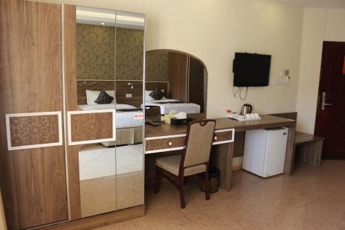 尼兹瓦阿尔迪亚酒店的酒店客房配有书桌和床。