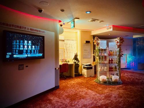 京都嵯峨野酒店（仅限成人）的墙上有大屏幕显示器的房间,