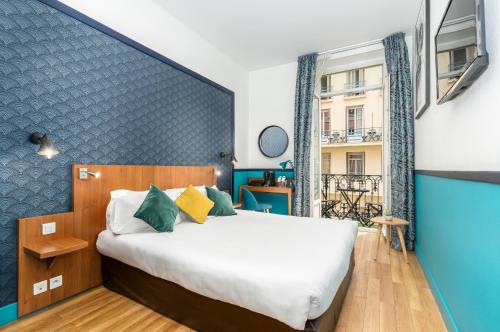 尼斯快乐文化拿普酒店的一间卧室设有一张蓝色墙壁的大床