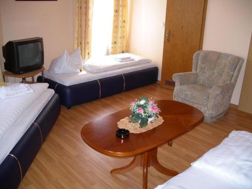 奥芬巴赫嘉兰伽尼酒店的一间设有两张床、一张桌子和一把椅子的房间