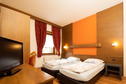 利维尼奥Residence San Marco by Alpenwhite的酒店客房设有两张床和一台平面电视。